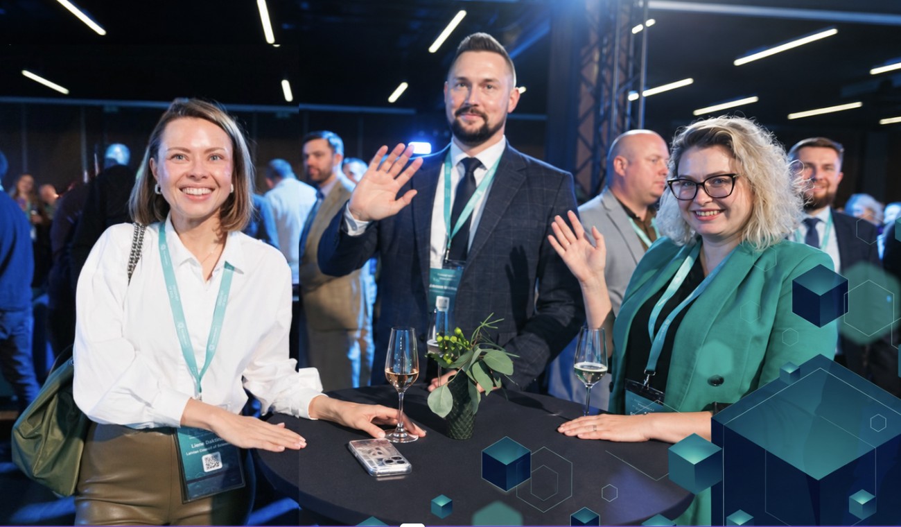 Liene Daktina with colleagues at a technology event networking table